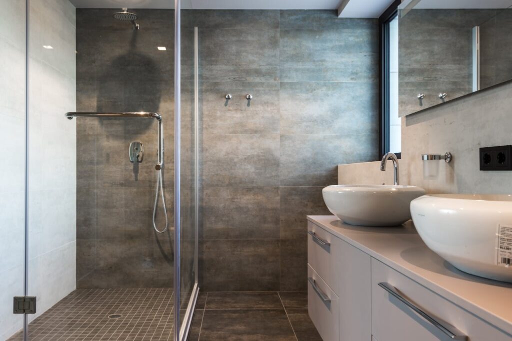 Stylish bathroom interior featuring ceramic sinks, glass shower, and elegant finishes.